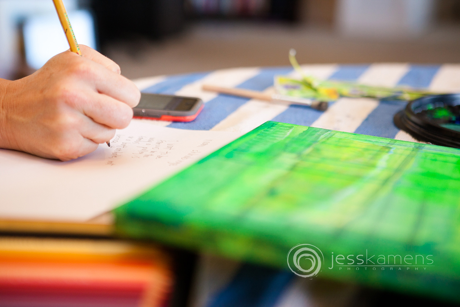 Renée writes a poem on a piece of paper that she is reading from her phone