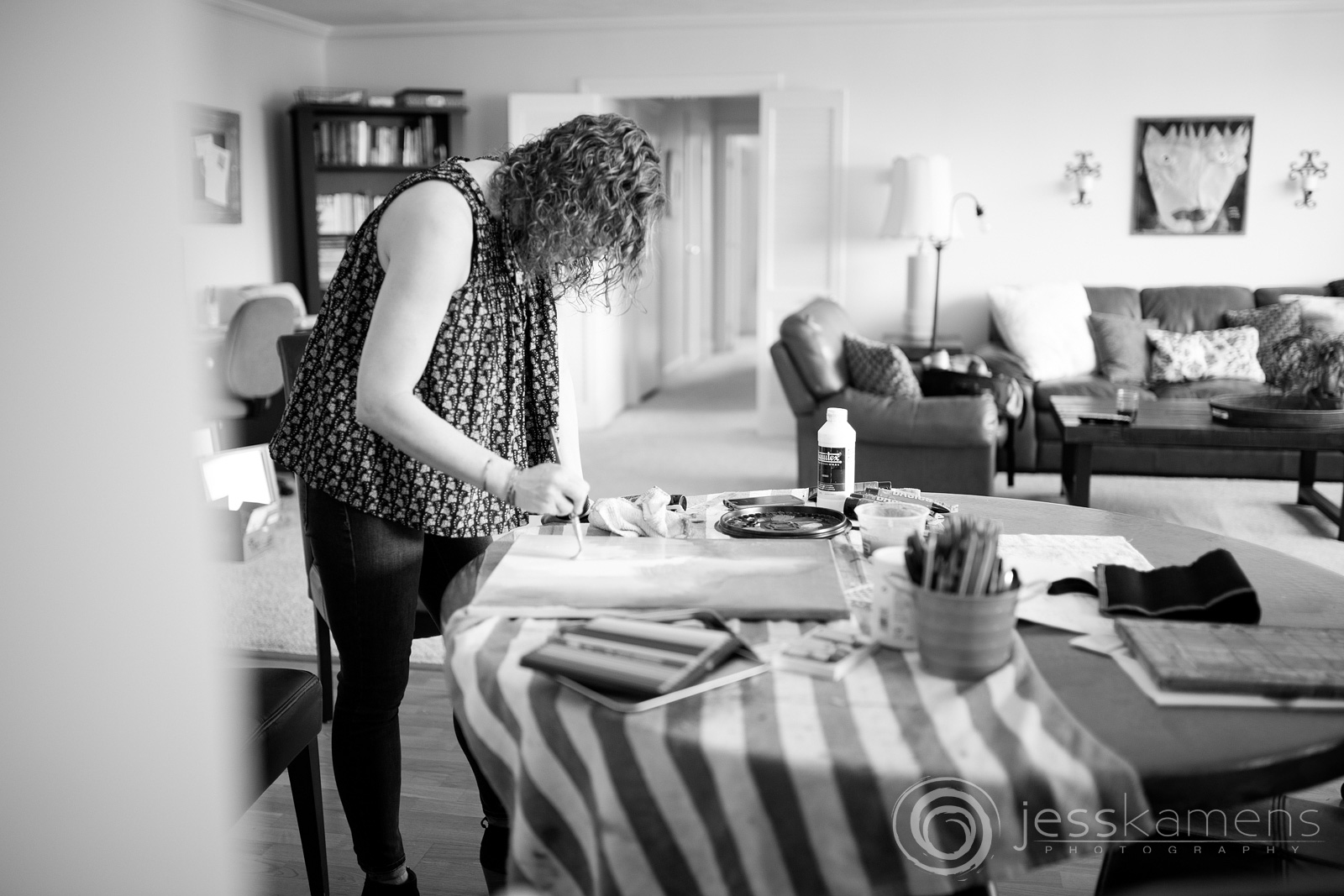 A black and white image of Renée painting in her home