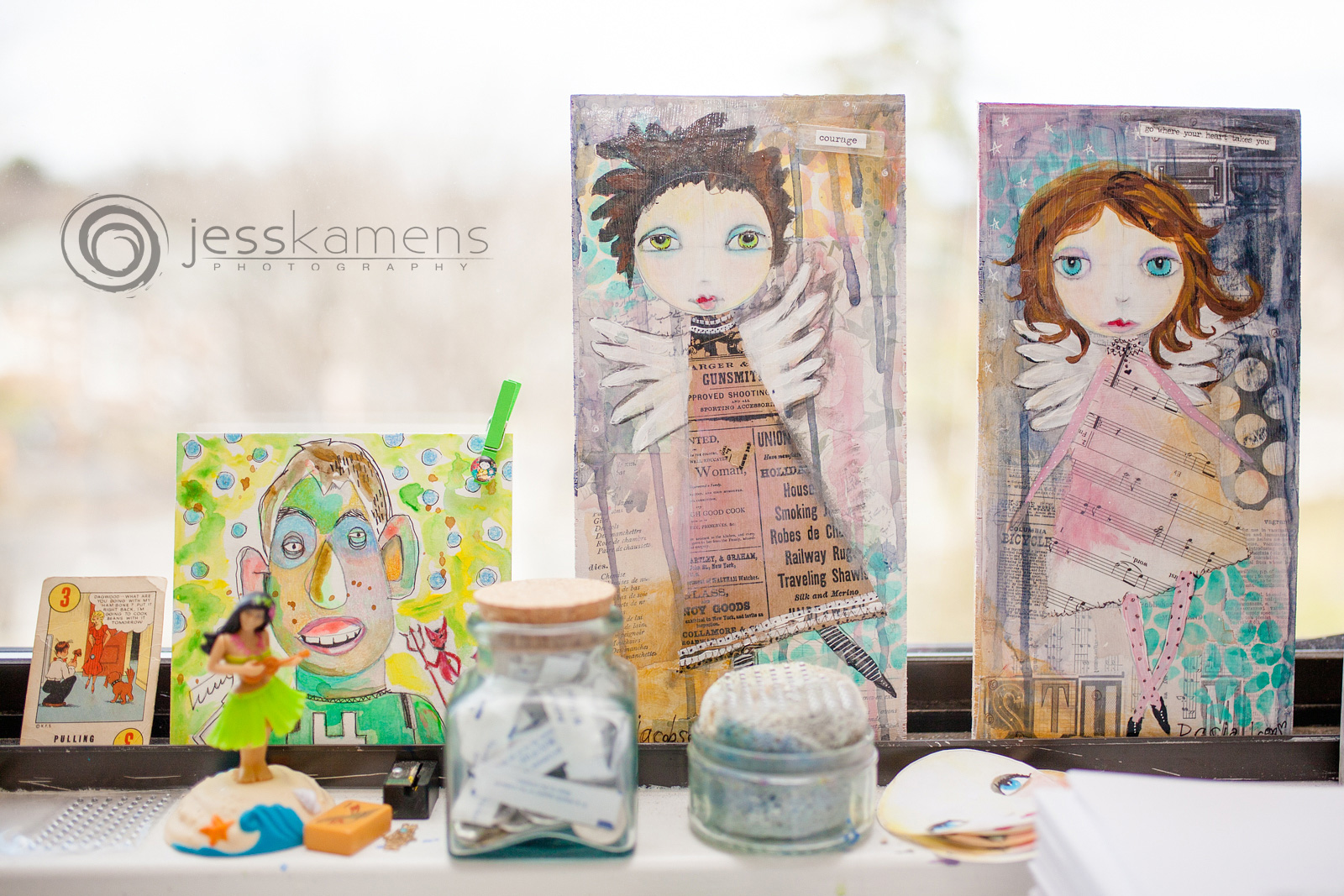 paintings and artwork balancing on a window sil