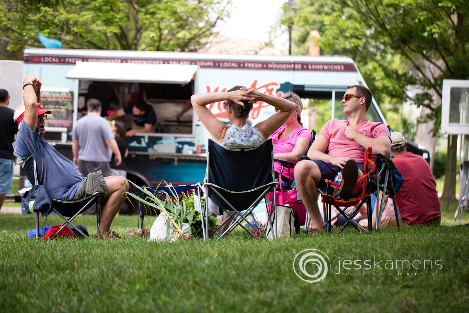 adults sitting on the grass in chairs talking