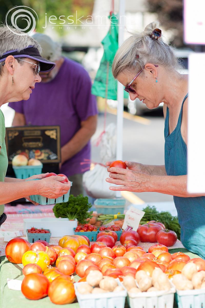 Jan from Deerhaven Farms in Naples talks with a customer about her organic tomatoes