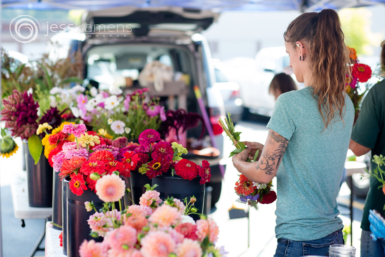 A woman from Chicory Blue Gardens in Spencerport arranges flowers to sell at Brighton Market