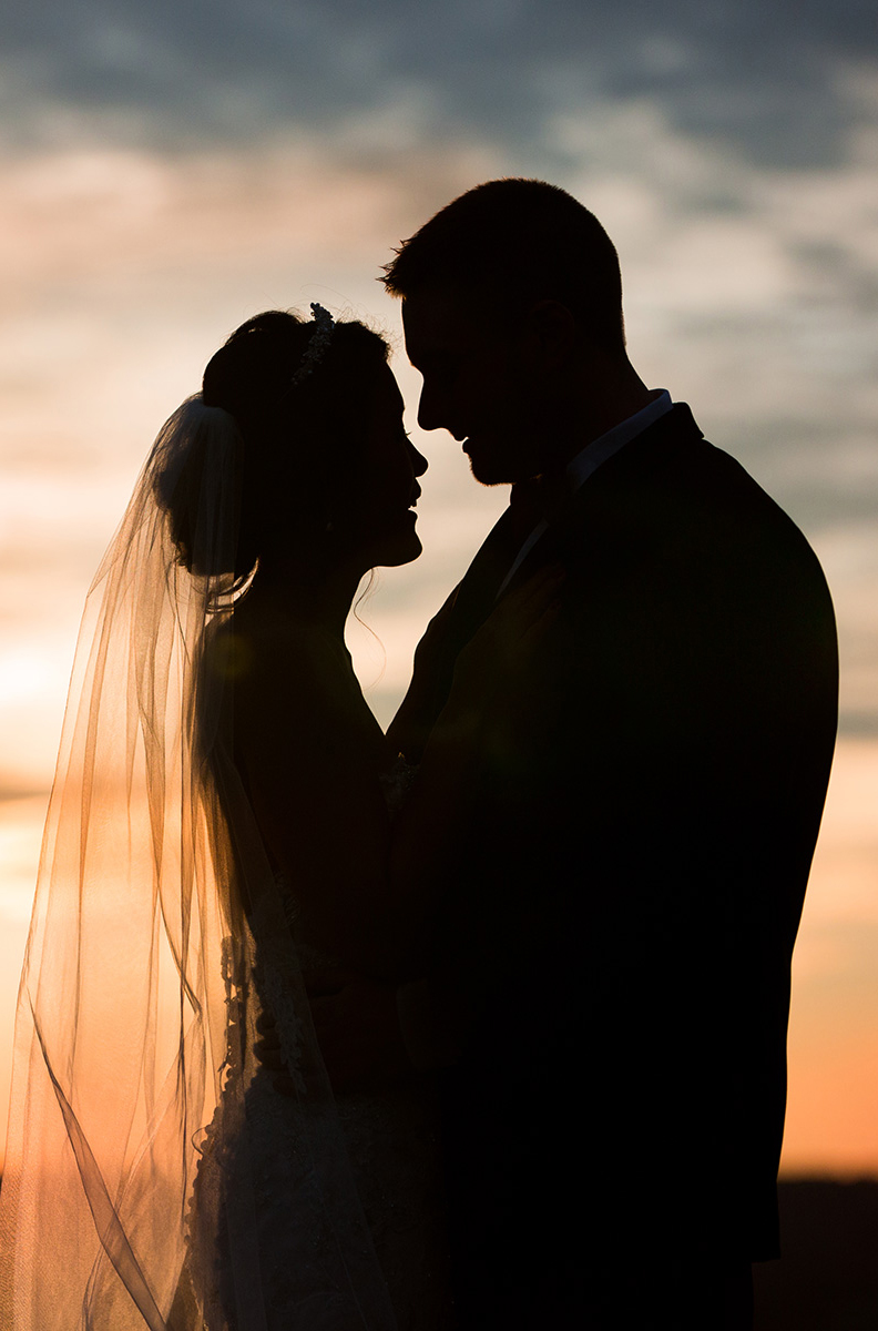 bride and groom silhouette in front of the sunset at the overlook at Woodcliff for their wedding photograph in Rochester