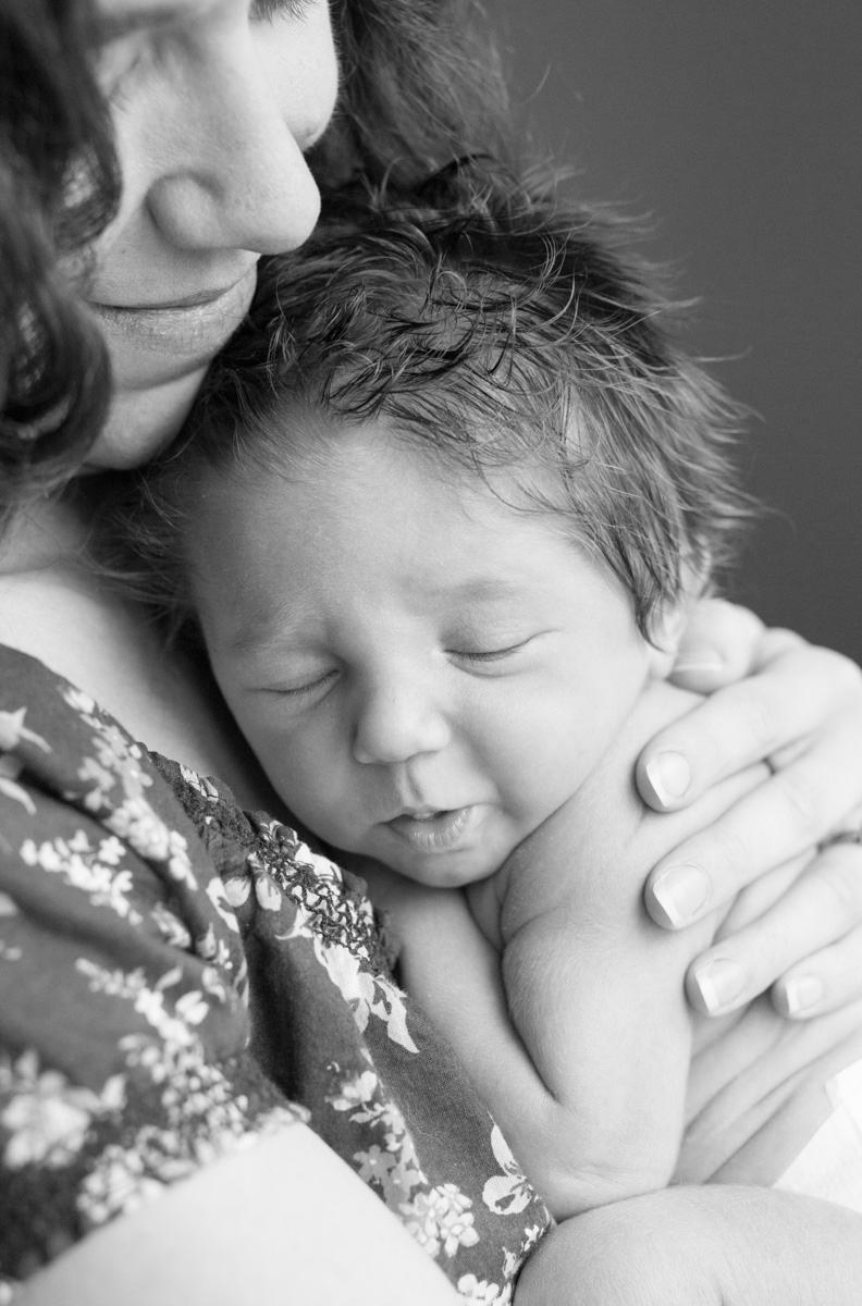black and white of mother holding new 7-day-old newborn during their newborn session