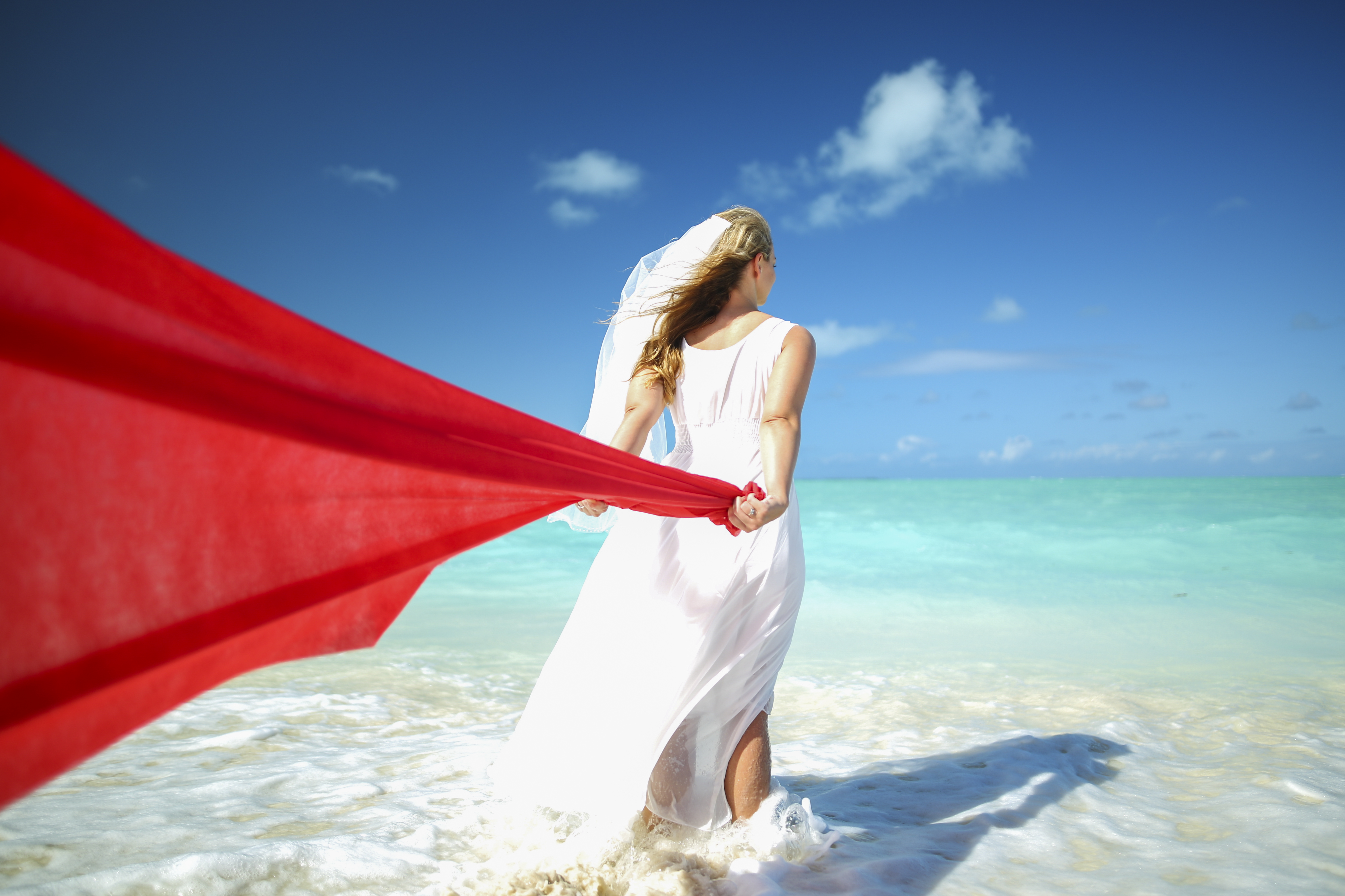 bahamas destination wedding adventure shoot, adventure session with red fabric in the ocean