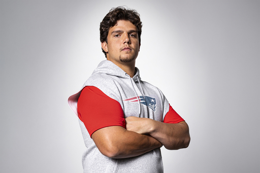 Portrait of New England Patriots left tackle Will Campbell with crossed arms looking at camera